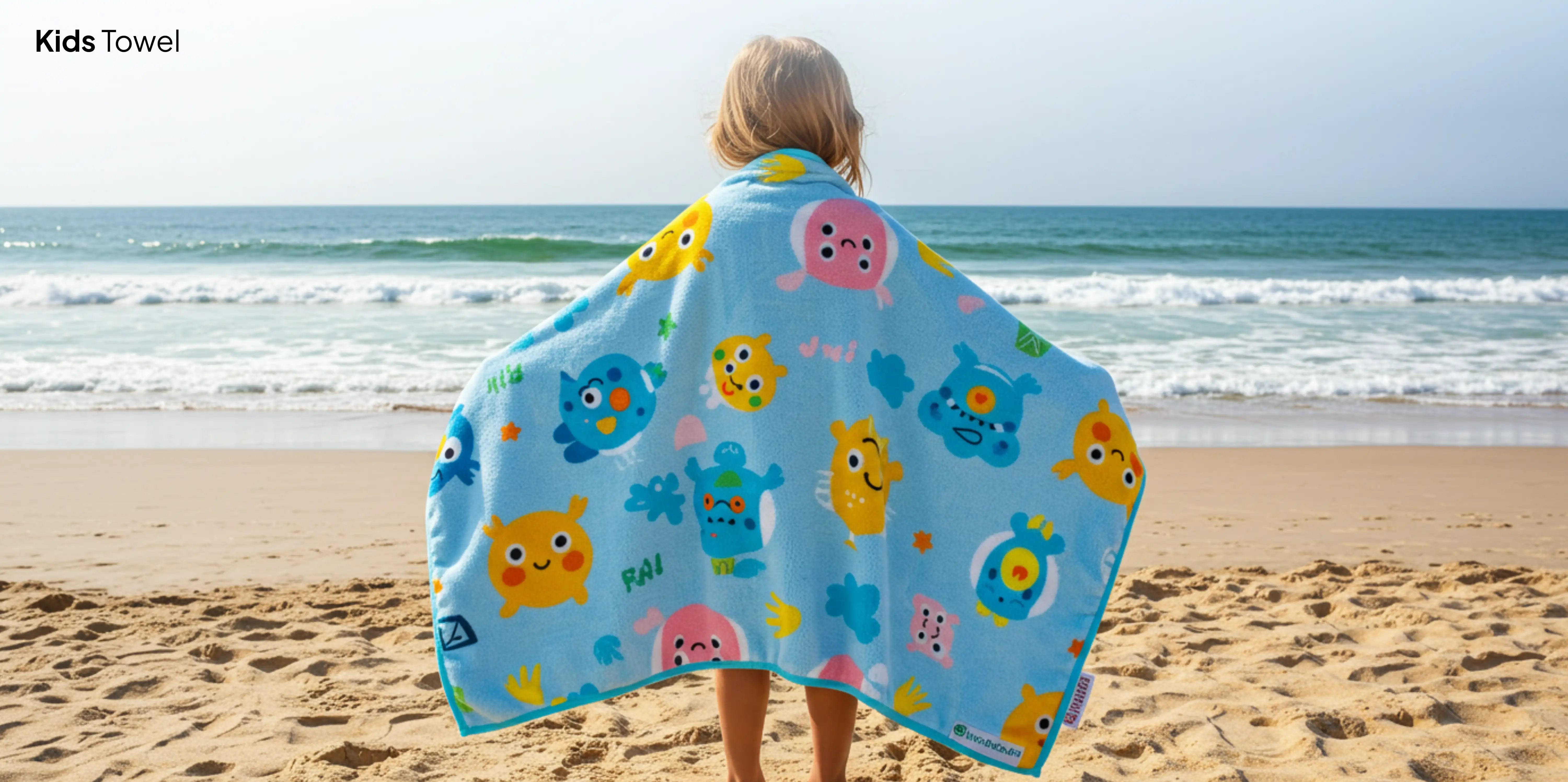 Child wearing blue monster beach towel.